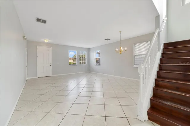 a view of an empty room with stairs and a window