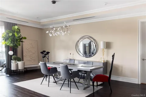 a dining room with furniture a potted plant and wooden floor
