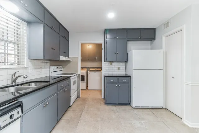 a kitchen with cabinets appliances a sink and a window
