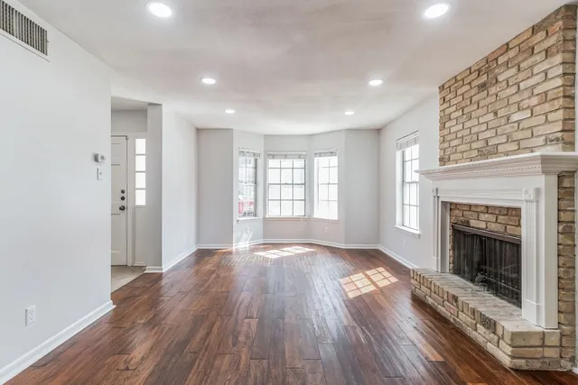 a view of a livingroom with wooden floor and a fireplace