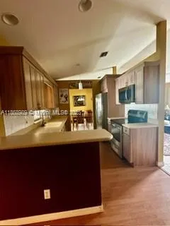 a kitchen with stainless steel appliances granite countertop a sink stove and refrigerator