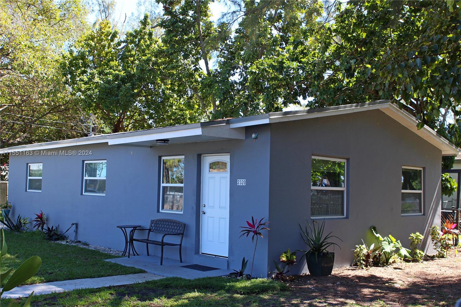 a couple of table and chairs in front of a house