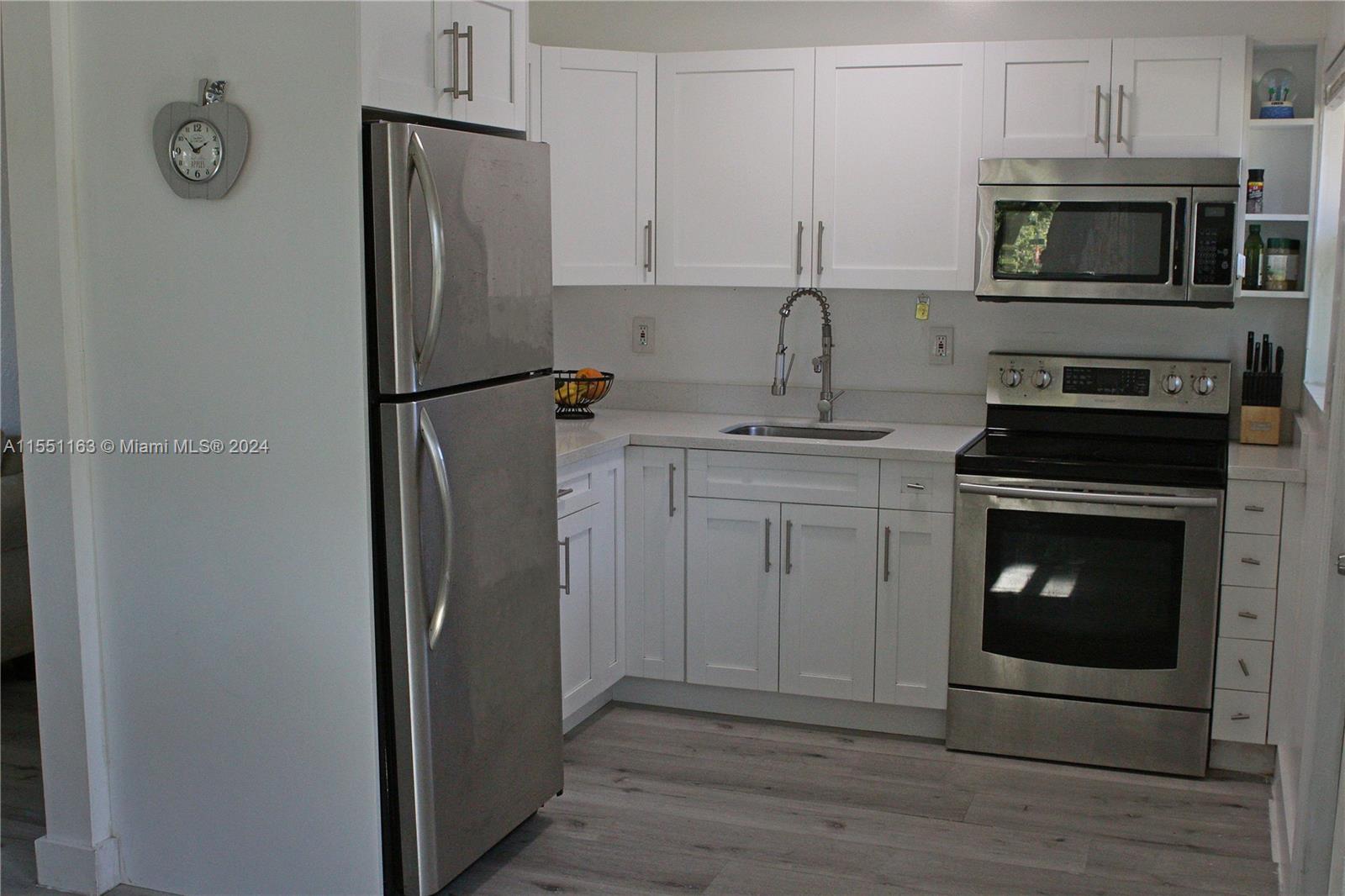Gladeview Miami, FL 33147 - Photo 11 of 25 a kitchen with cabinets stainless steel appliances and a wooden floor