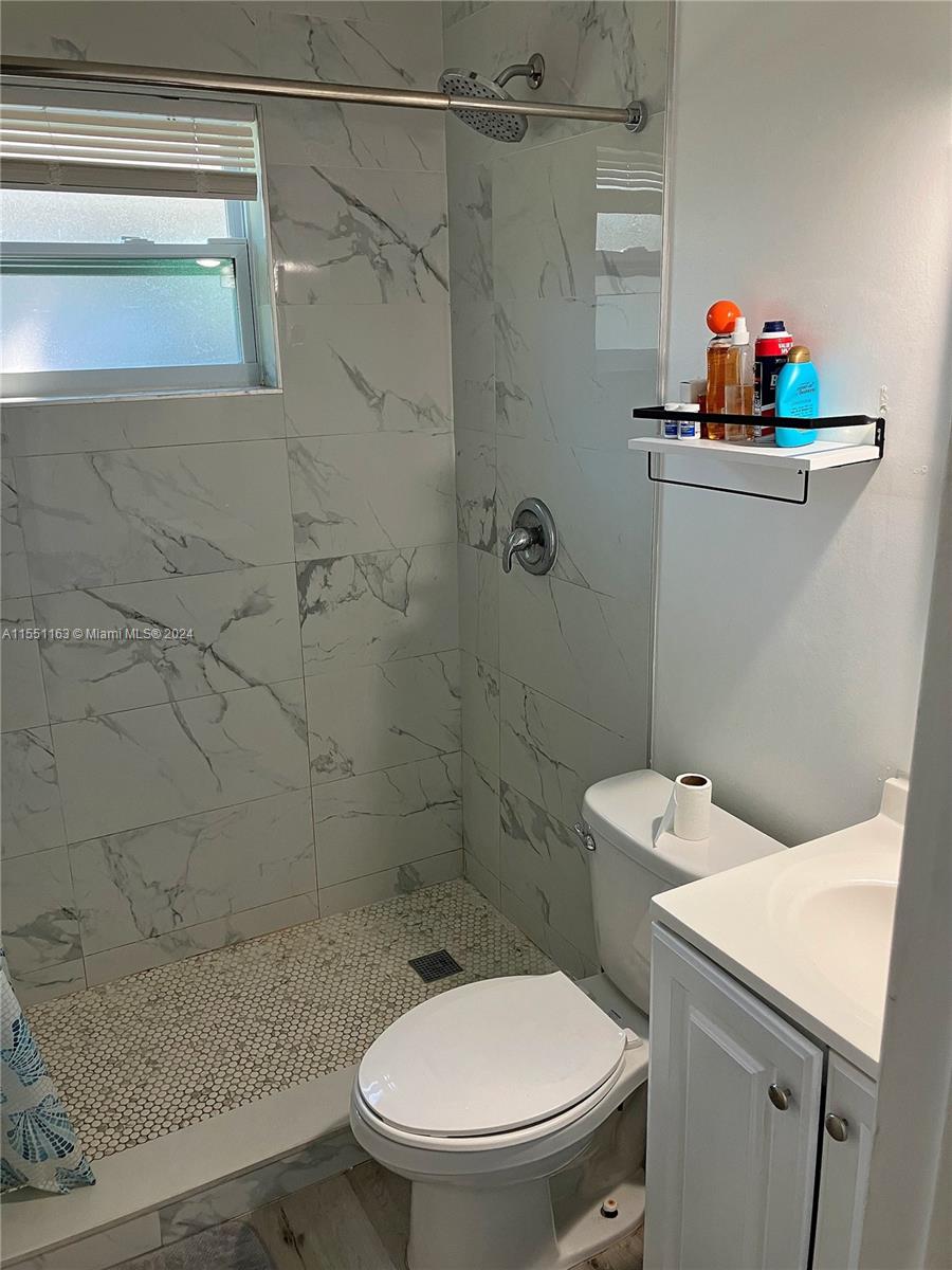 Gladeview Miami, FL 33147 - Photo 14 of 25 a white toilet sitting next to a bathroom sink and a shower