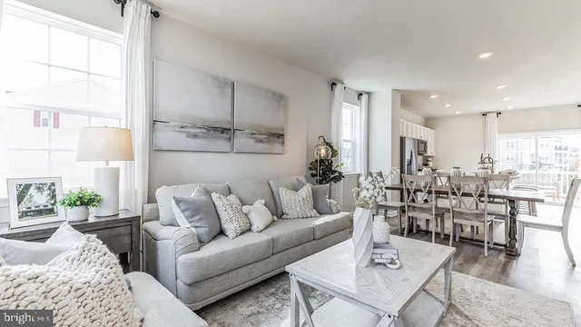 a living room with lots of furniture and view of kitchen