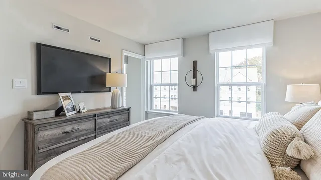 a bedroom with a bed and a flat screen tv on dresser