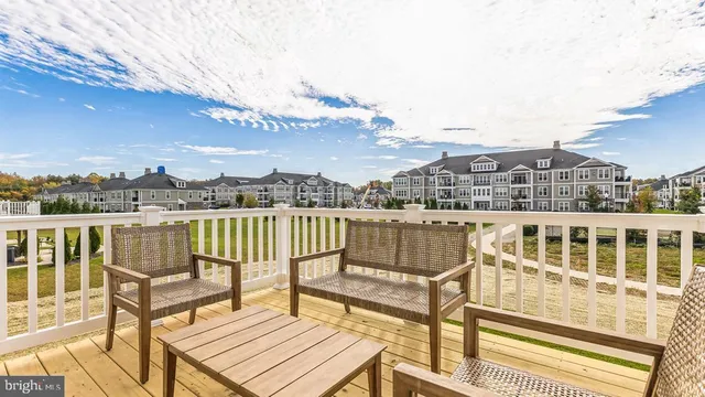 a view of a balcony with wooden chairs