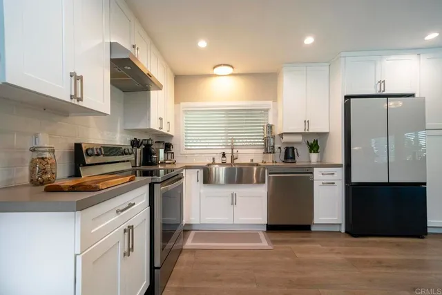 a kitchen with a refrigerator and a stove top oven