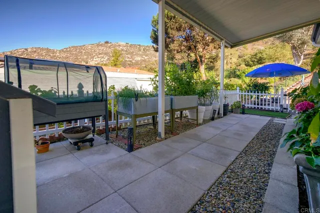 a view of a patio with a table and chairs under an umbrella
