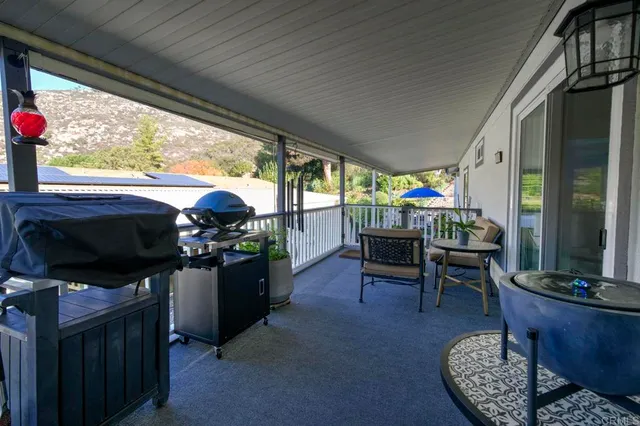 a living room with furniture a flat screen tv and floor to ceiling window
