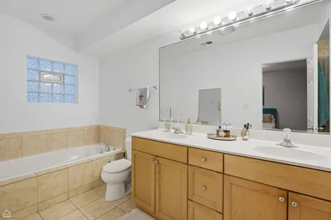 a bathroom with a toilet a bath tub a sink and mirror