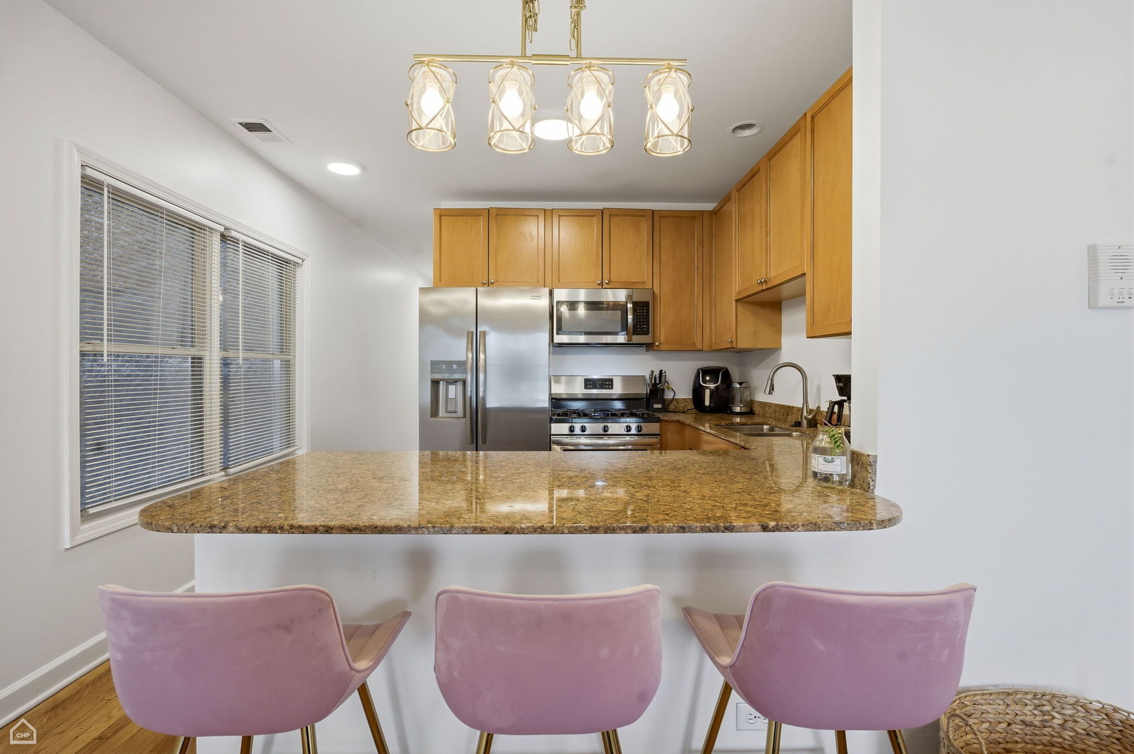 2455 West Harrison Street, Unit 2 Chicago, IL 60612 - Photo 6 of 20 a kitchen with stainless steel appliances granite countertop a sink window and chairs
