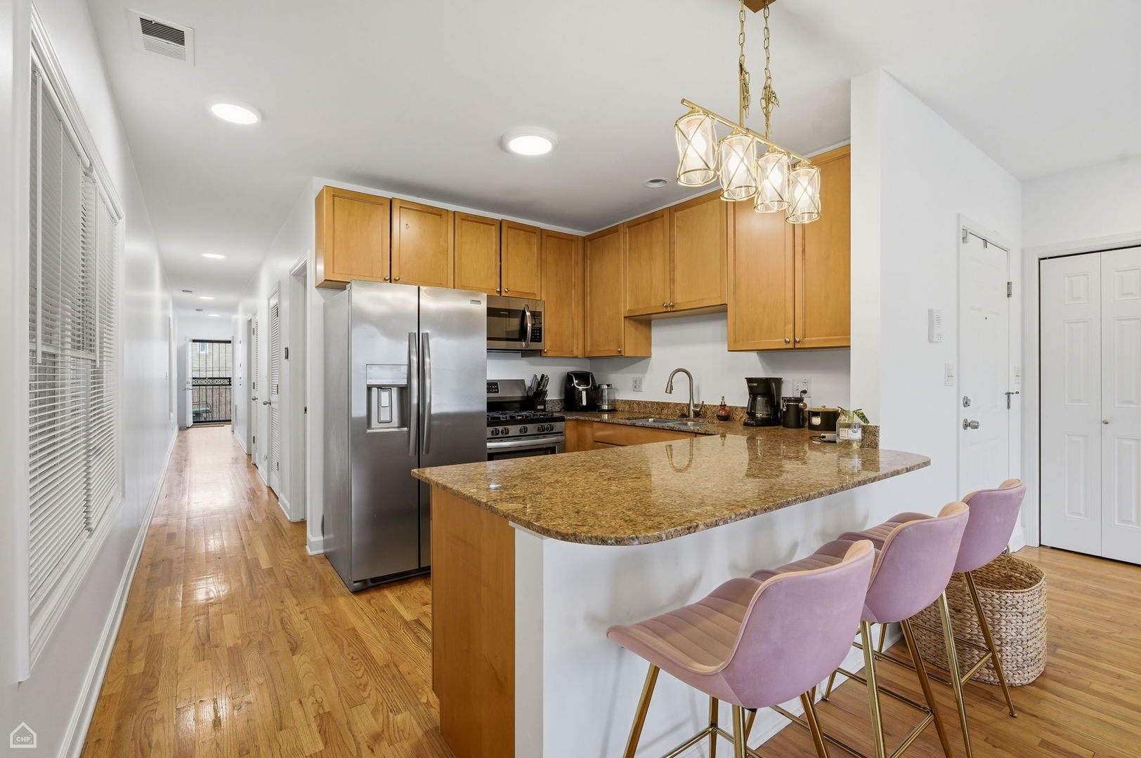 2455 West Harrison Street, Unit 2 Chicago, IL 60612 - Photo 9 of 20 a kitchen with stainless steel appliances granite countertop a refrigerator a sink dishwasher a stove and a dining table with wooden floor