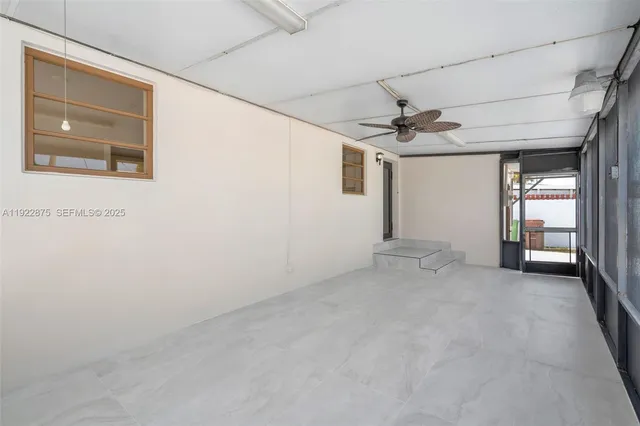 a view of a livingroom with a ceiling fan and window