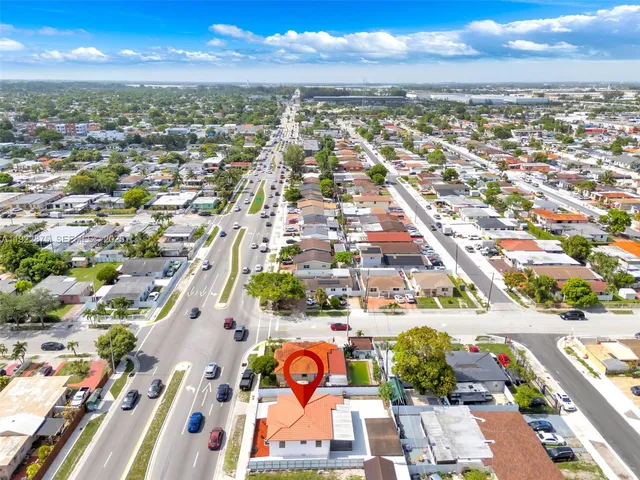 an aerial view of residential houses with outdoor space and ocean view