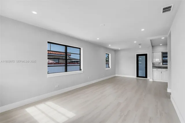 an empty room with windows and entrance