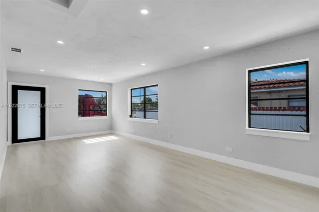 an empty room with windows and cabinet