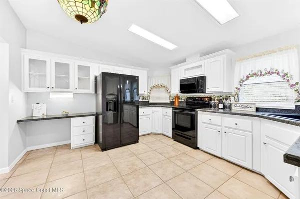 a kitchen with granite countertop a refrigerator stove top oven and sink