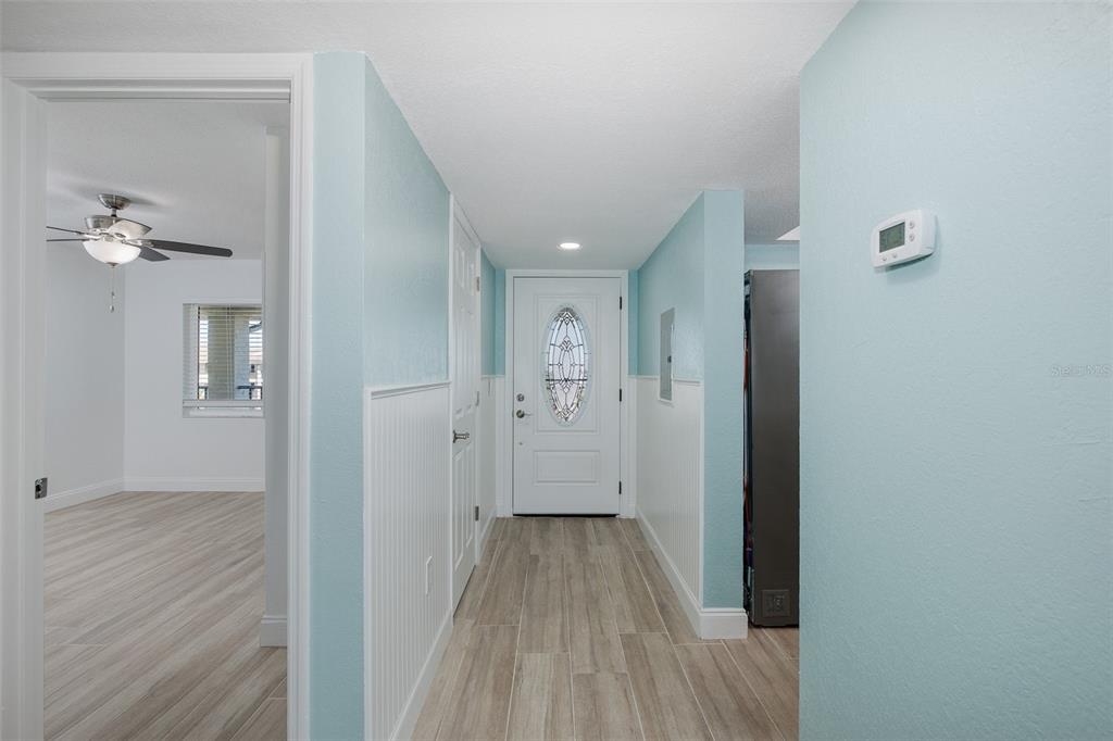 8150 Brent Street, Unit 742 Port Richey, FL 34668 - Photo 14 of 51 a view of a hallway with wooden floor and a chandelier