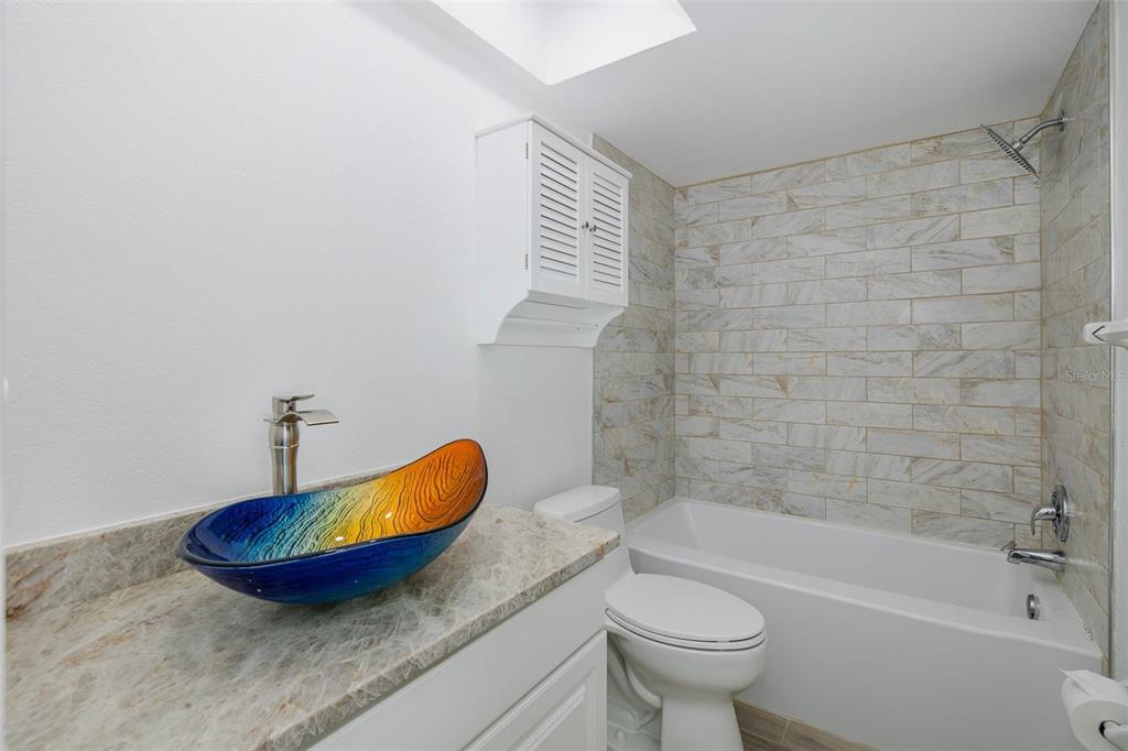8150 Brent Street, Unit 742 Port Richey, FL 34668 - Photo 18 of 51 a bathroom with a granite countertop toilet a sink and bathtub