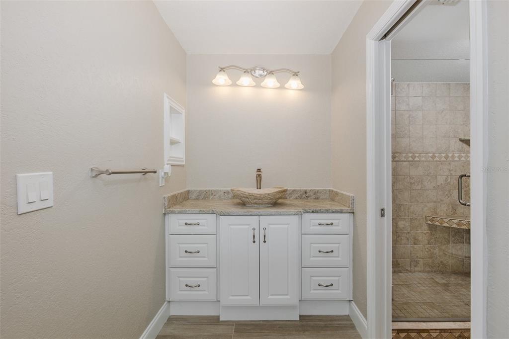 8150 Brent Street, Unit 742 Port Richey, FL 34668 - Photo 30 of 51 a bathroom with a granite countertop sink a mirror and a vanity