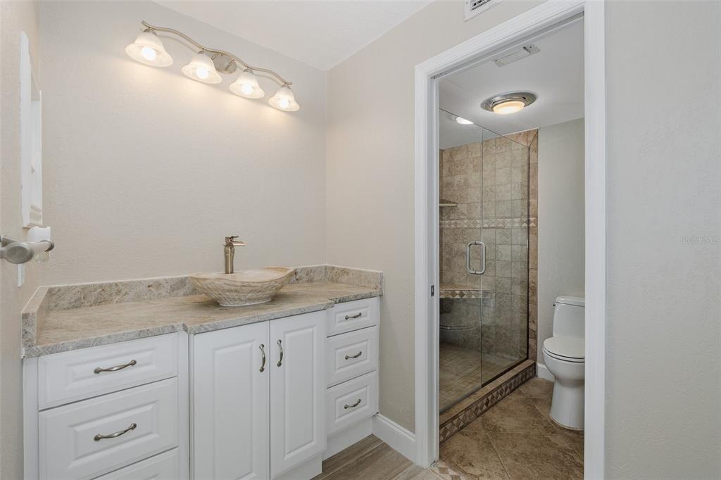 8150 Brent Street, Unit 742 Port Richey, FL 34668 - Photo 31 of 51 a bathroom with a granite countertop sink a mirror and shower