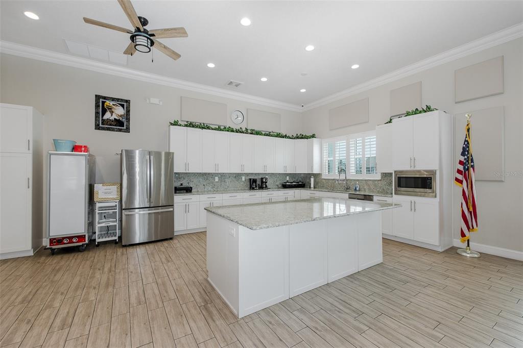 8150 Brent Street, Unit 742 Port Richey, FL 34668 - Photo 51 of 51 a large kitchen with a center island wooden floor and stainless steel appliances