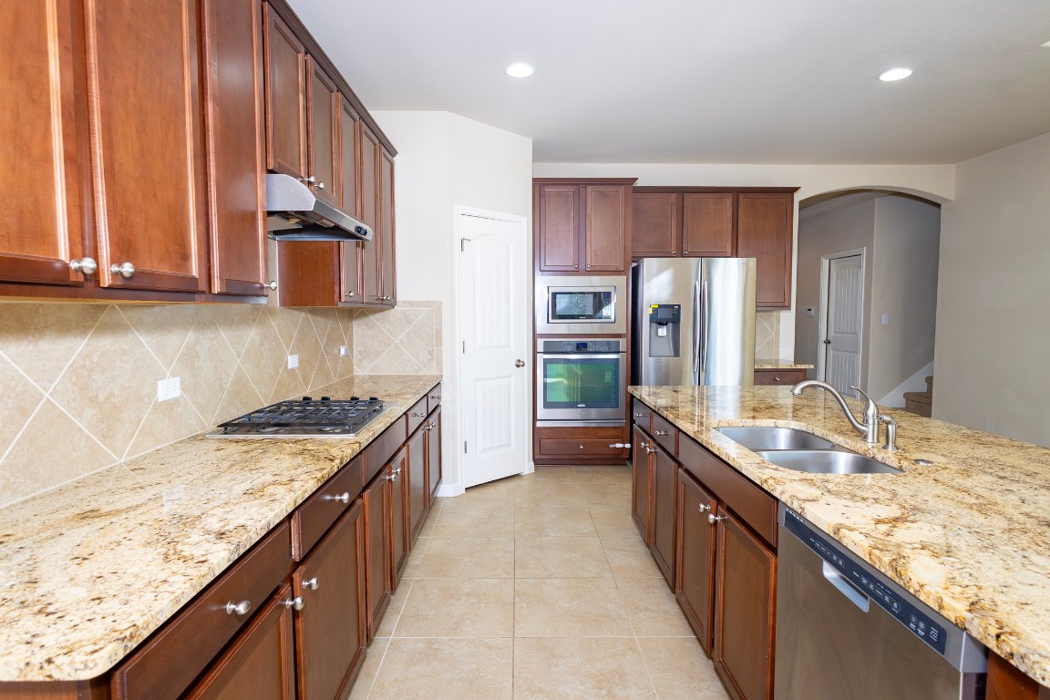 108 Mark Brooks Cove Round Rock, TX 78664 - Photo 10 of 24 a large kitchen with granite countertop a sink and a refrigerator