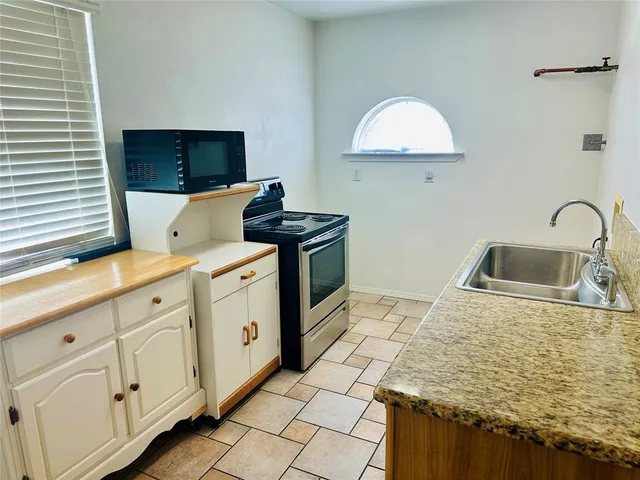 a kitchen with granite countertop white cabinets and white appliances