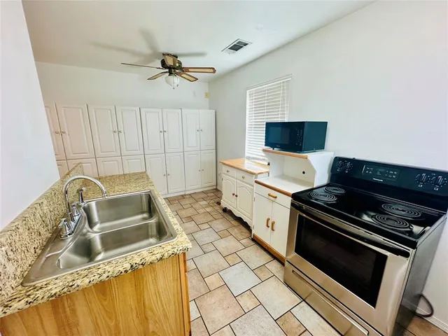 a kitchen with a sink appliances and cabinets