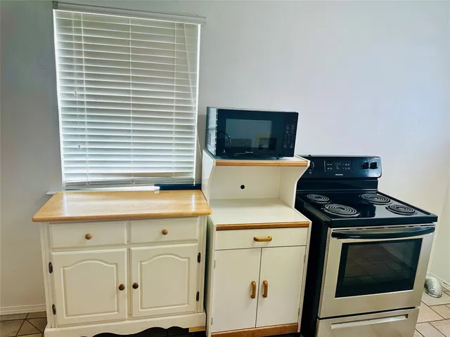 a kitchen with white cabinets and black appliances