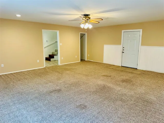 a view of an empty room with a ceiling fan