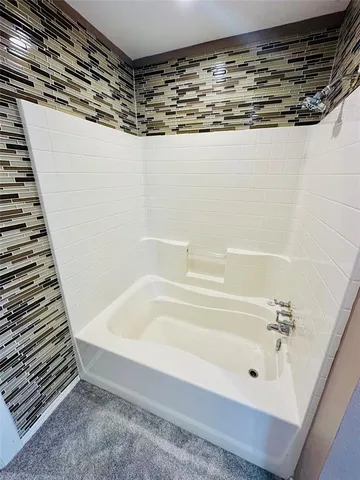 a bathroom with a shower and a bath tub