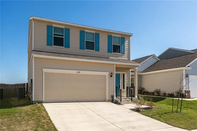 a front view of a house with yard and garage