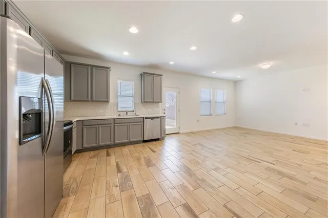 a kitchen with stainless steel appliances a refrigerator sink and cabinets