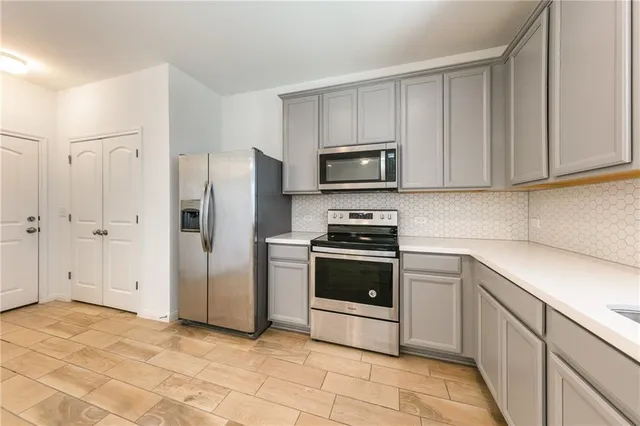 a kitchen with stainless steel appliances a stove a sink and a refrigerator