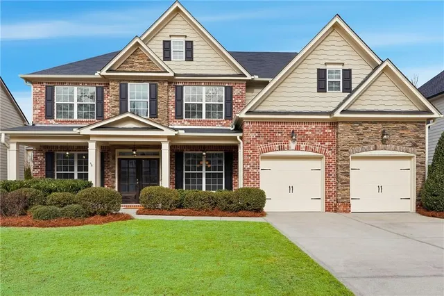 a front view of a house with a yard and garage