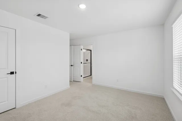 an empty room with windows and closet