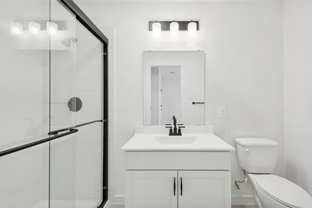 a bathroom with a sink a toilet and shower