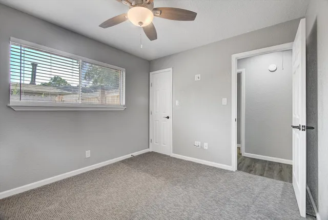 an empty room with closet and a chandelier fan