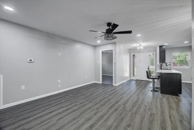 a view of a livingroom with a flat screen tv wooden floor and a ceiling fan