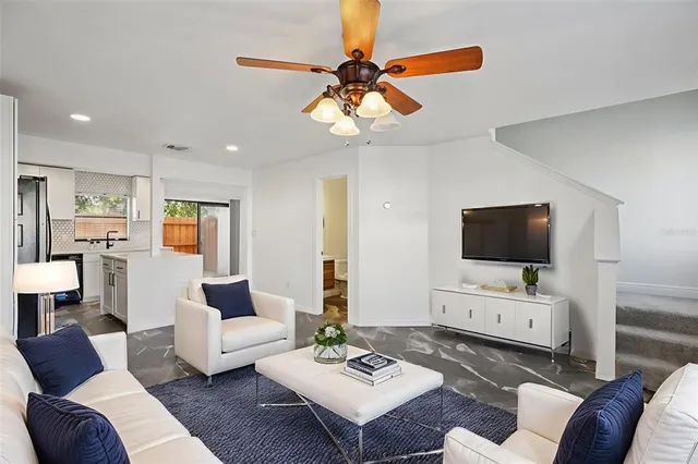 a living room with furniture a flat screen tv and a chandelier