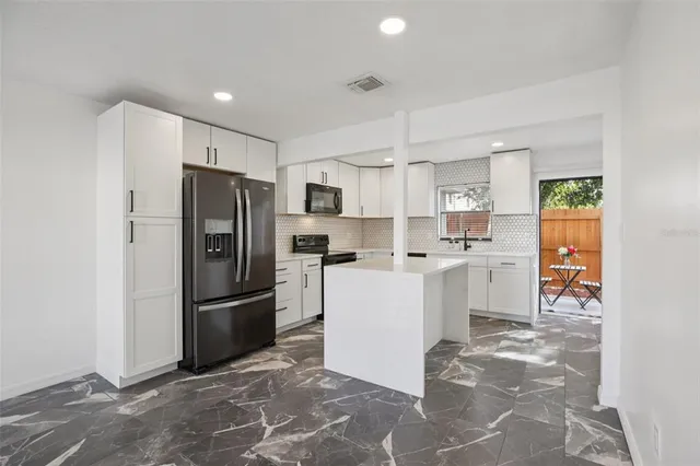 a kitchen with refrigerator and cabinets
