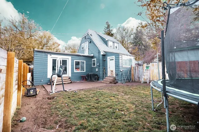 a view of a house with backyard sitting area and garden