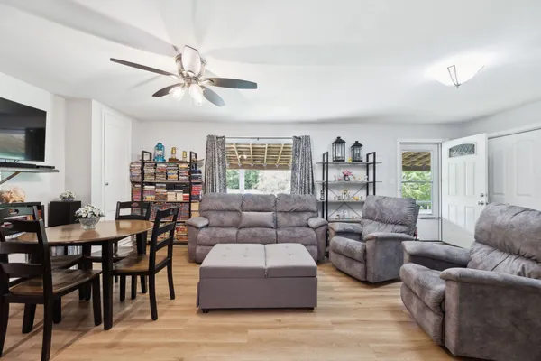 a kitchen with stainless steel appliances granite countertop a refrigerator a sink a stove and island with wooden floor