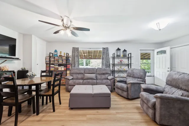 a kitchen with stainless steel appliances granite countertop a refrigerator a sink a stove and island with wooden floor