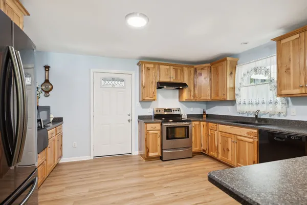 a kitchen with stainless steel appliances granite countertop a stove a sink and a microwave