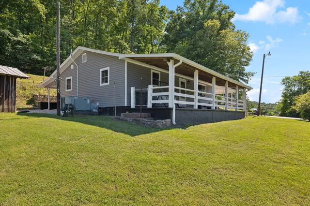 a view of a house with a yard and sitting area