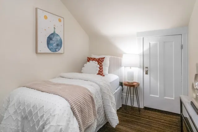 a bedroom with a bed and painting on the wall