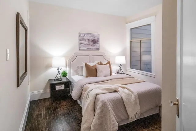 a bedroom with bed and a painting on the wall